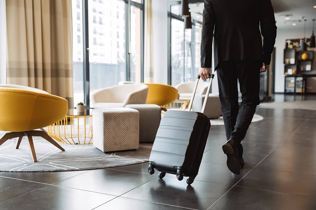 gentleman walking through hotel lobby with suitcase