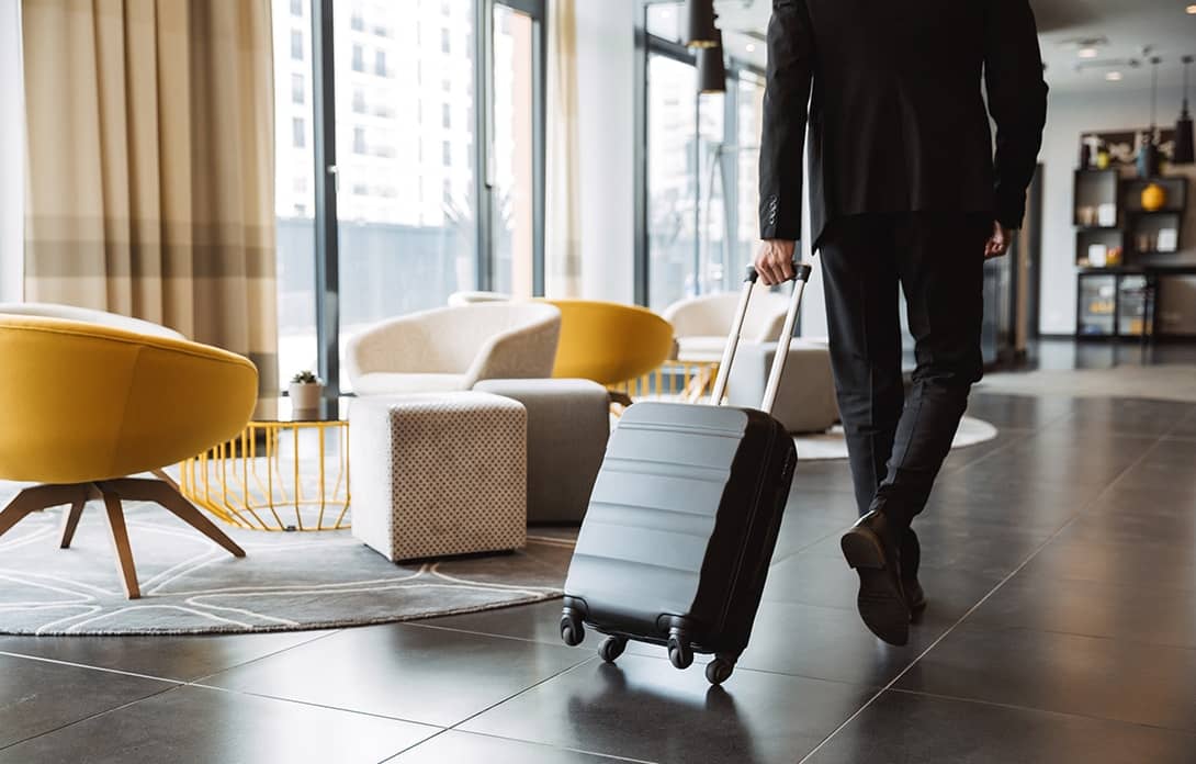 gentleman walking through hotel lobby with suitcase