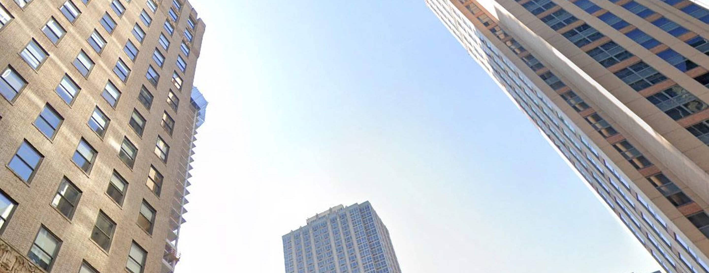 a ground view of four large skyscrapers